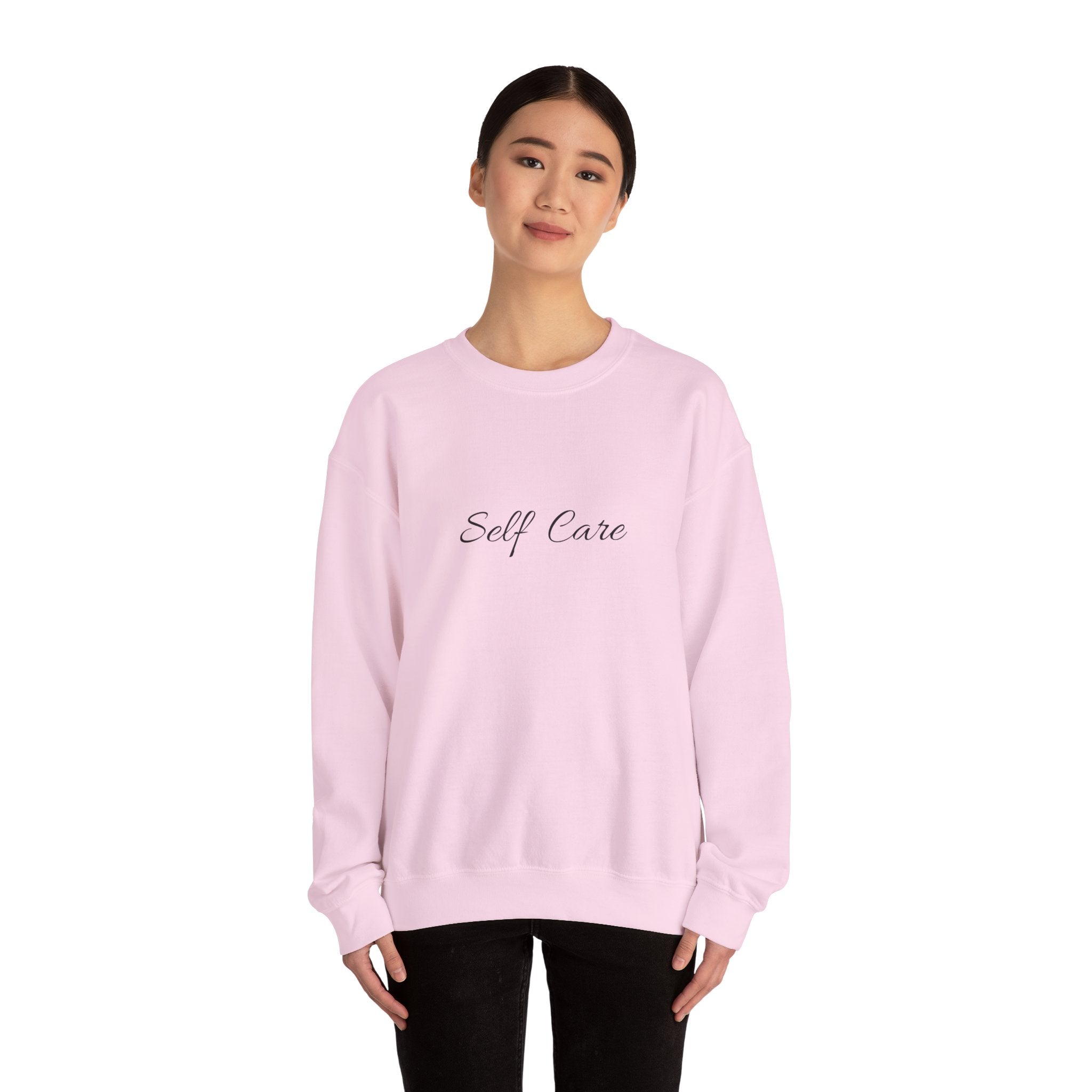 Person wearing a Light pink sweatshirt with 'Self Care' text on a white background