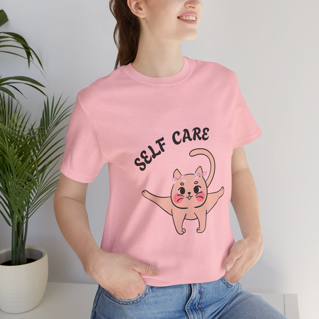Person wearing a pink t-shirt with a cat illustration and 'SELF CARE' text.