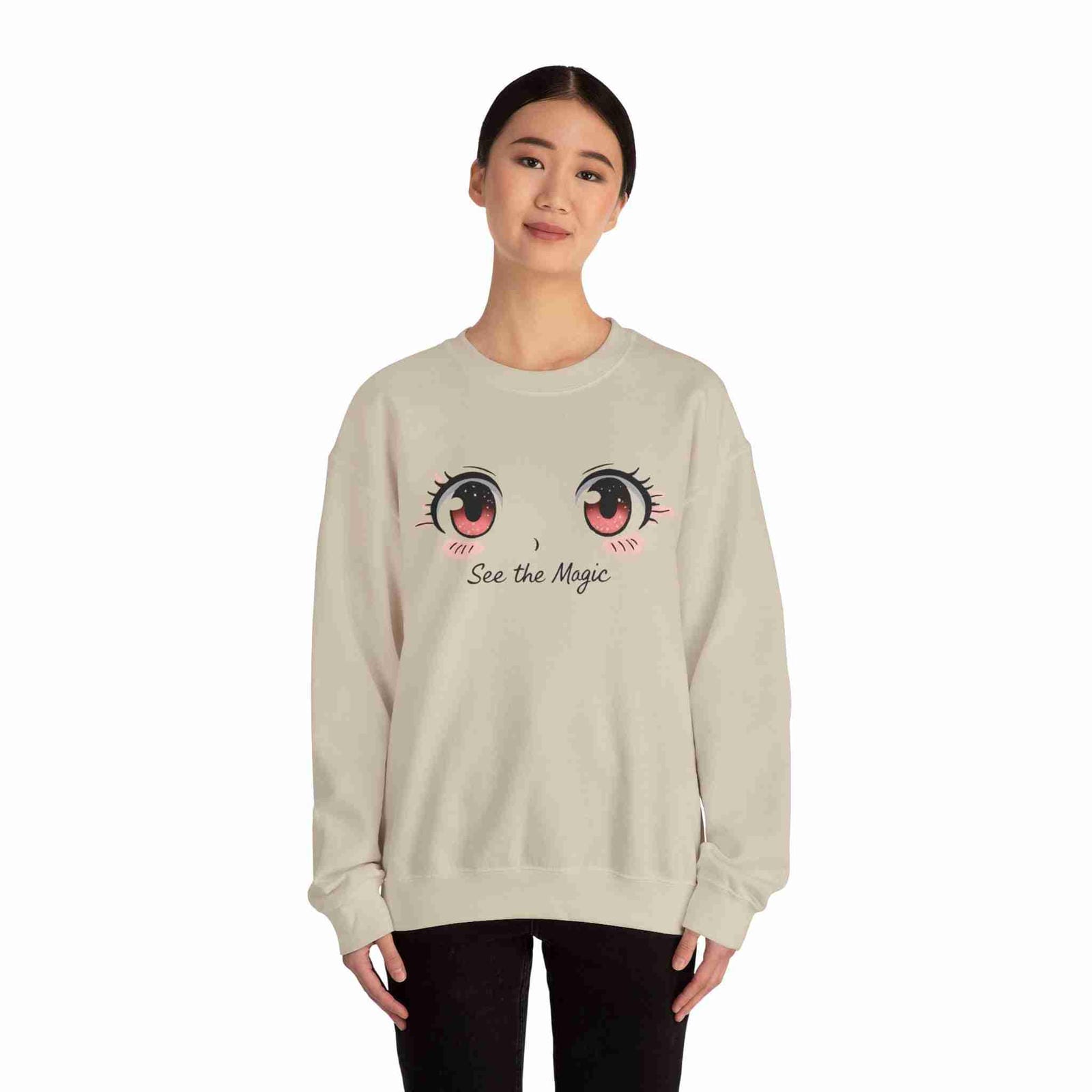 Sand sweatshirt with cartoon eyes and 'See the Magic' text worn by a person on a white background