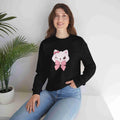 Woman wearing a black sweatshirt with a white cat design and pink bow, sitting on a white surface with a plant in the background.
