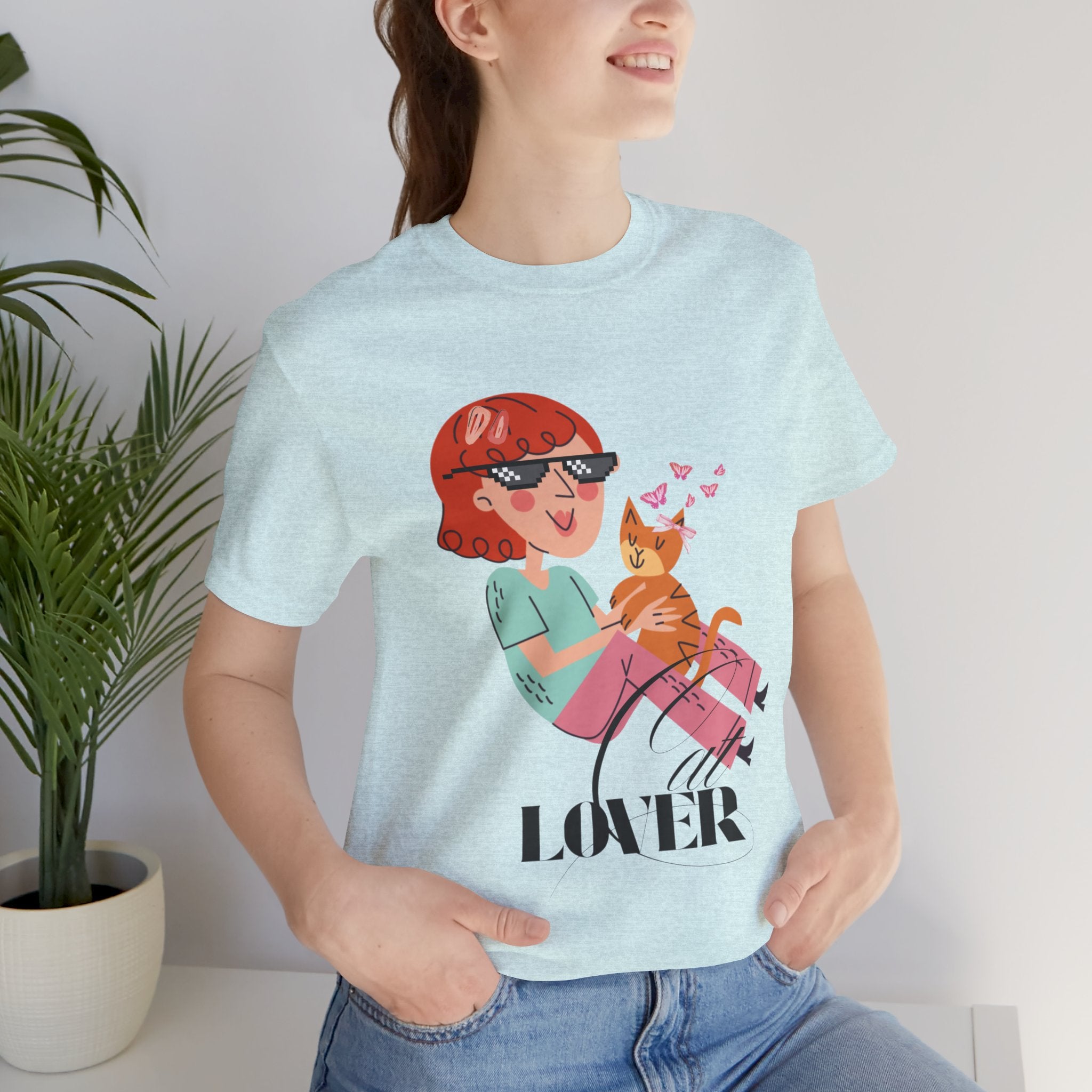 Person wearing a Heather Prism Ice blue t-shirt with a graphic design and the word 'Cat LOVER'.