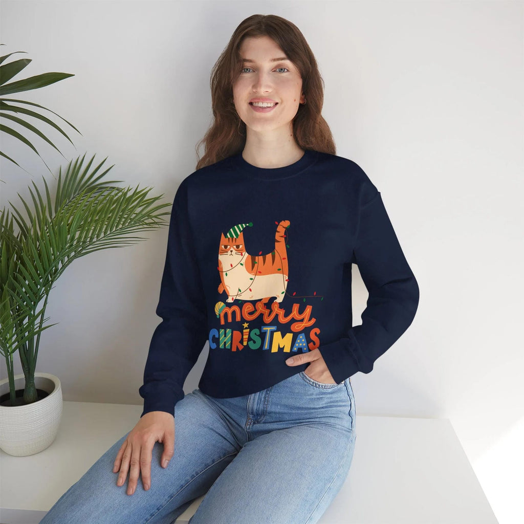 Person wearing a navy blue sweatshirt with a Christmas design, sitting on a white surface with a plant in the background.