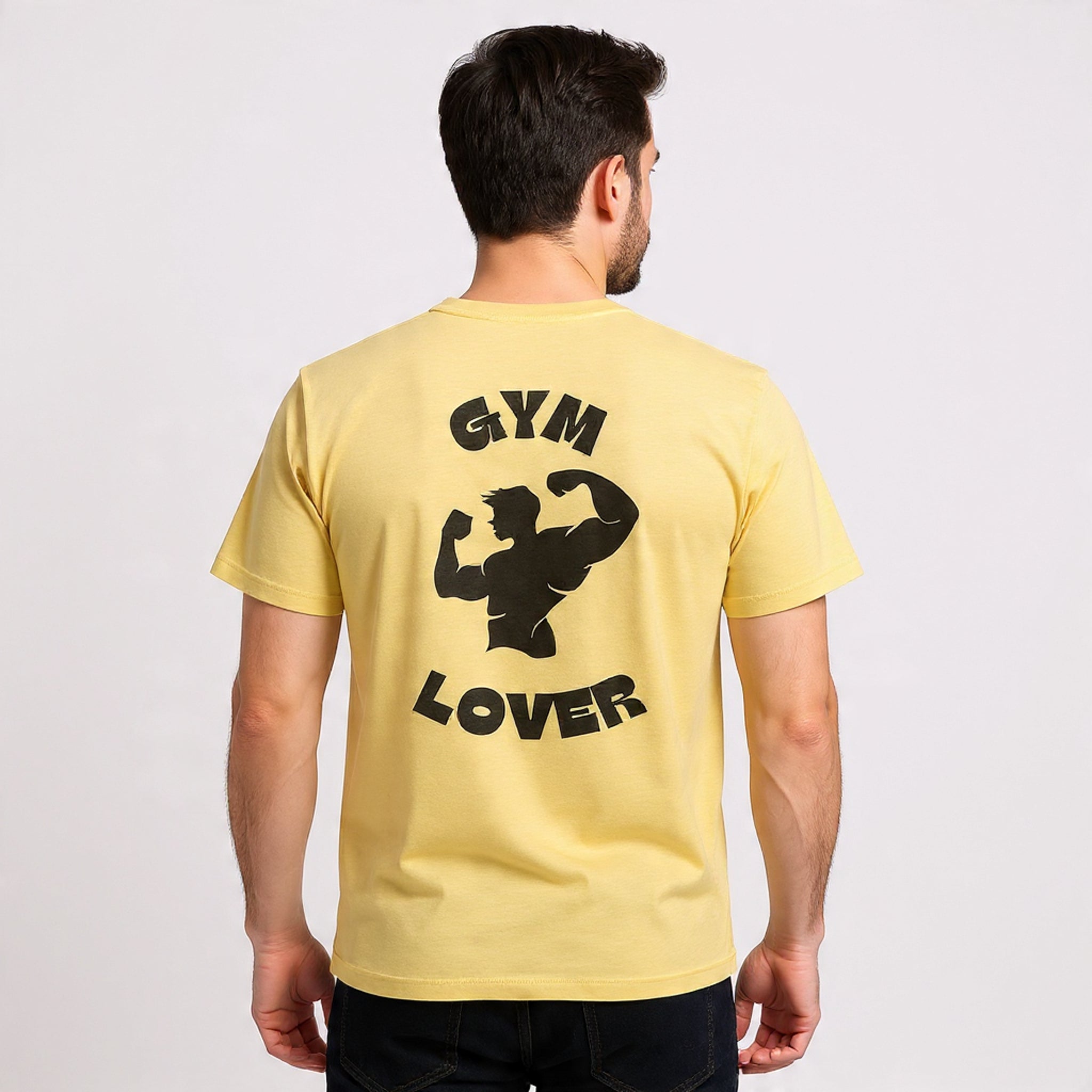 Man wearing a Solid Banana Cream t-shirt with 'GYM LOVER' text and graphic on the back against a plain background