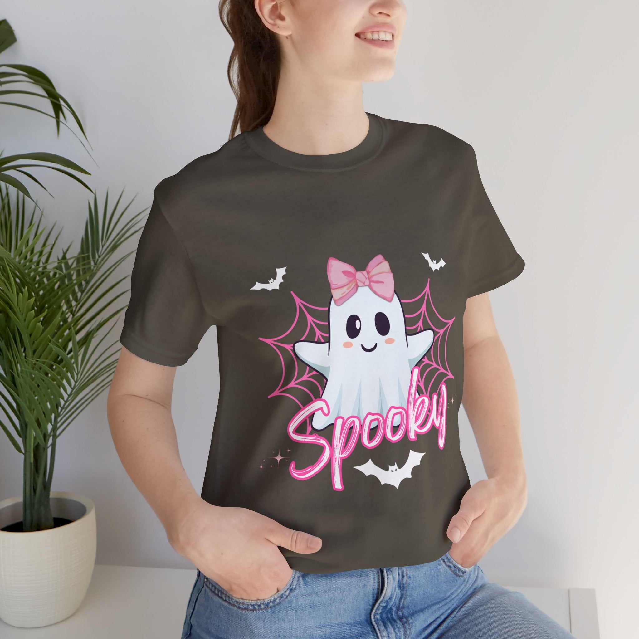 Person wearing a Army t-shirt with a ghost design and 'Spooky' text, standing indoors.