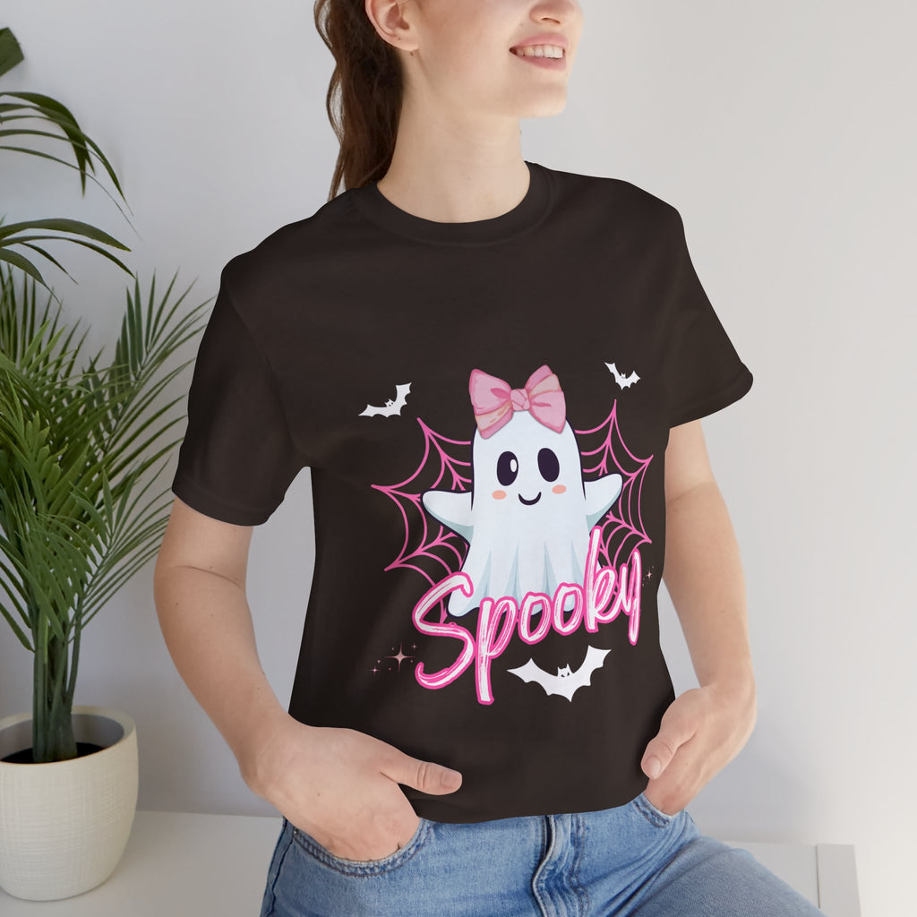 Person wearing a brown t-shirt with a ghost design and 'Spooky' text, standing indoors.