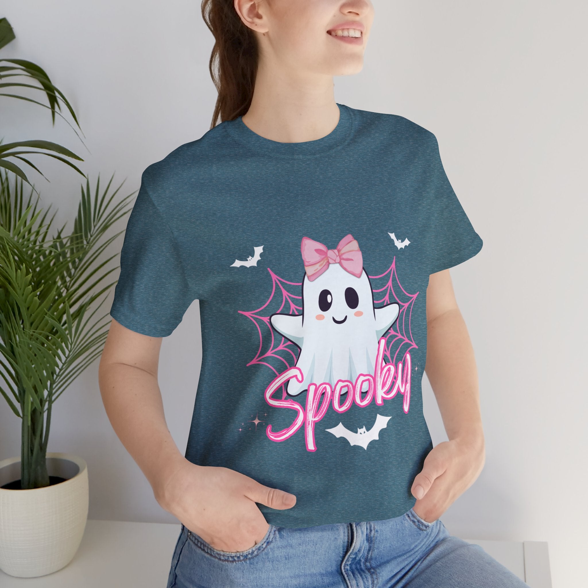 Person wearing a Heather deep Teal t-shirt with a cartoon ghost and 'Spooky' text design.