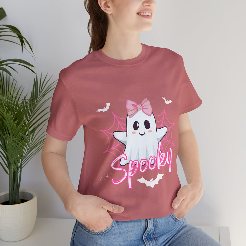 Person wearing a mauve t-shirt with a ghost graphic and 'Spooky' text, standing indoors.