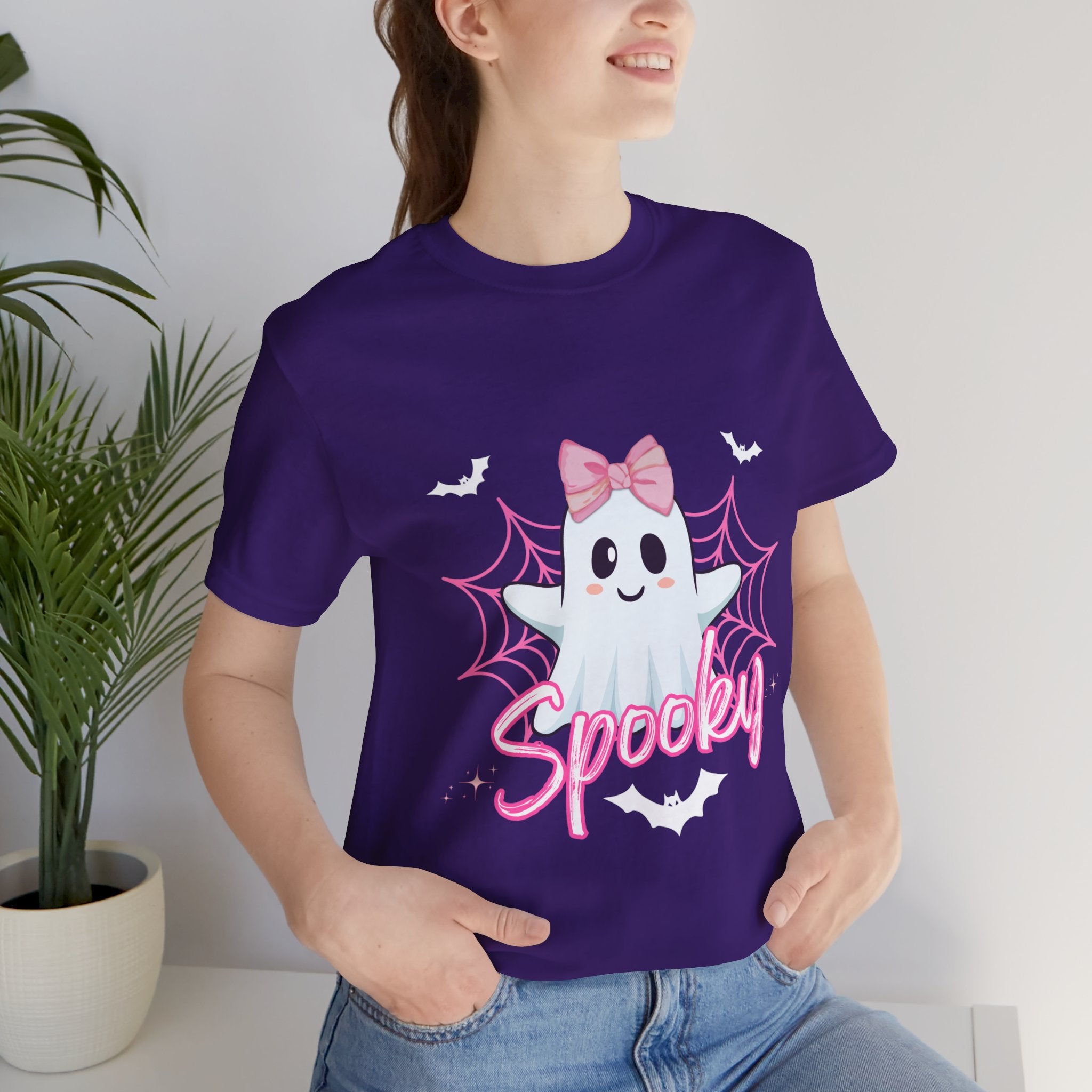 Person wearing a Team purple t-shirt with a ghost design and 'Spooky' text, standing indoors.
