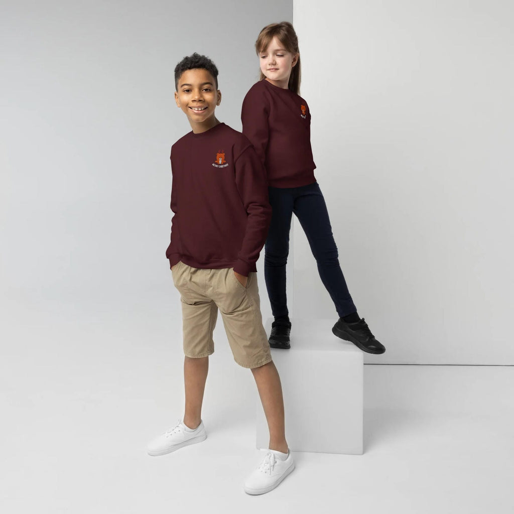 Two children wearing maroon sweatshirts with a logo on a white background