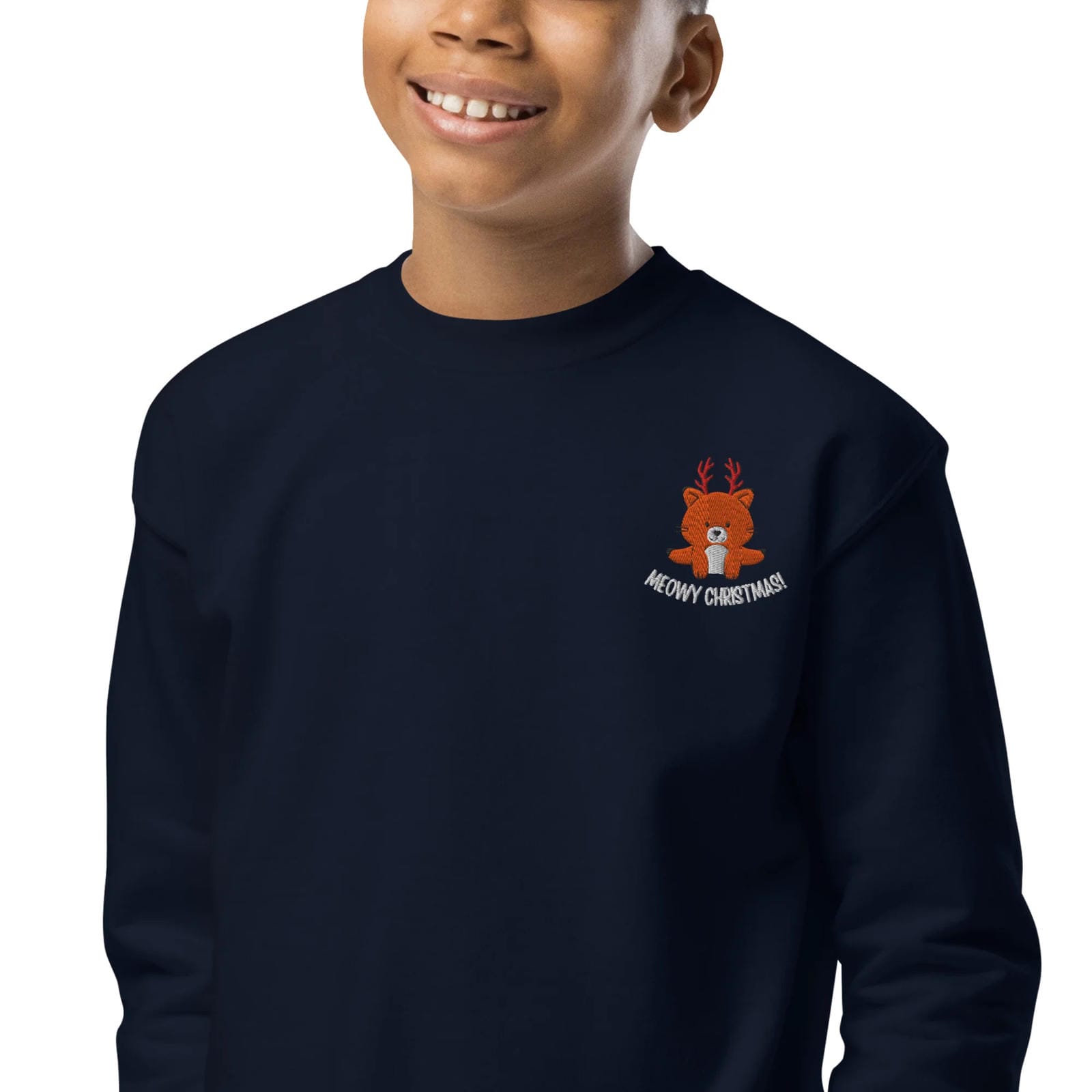 Child wearing a navy blue sweatshirt with a teddy bear design and 'Meowy Christmas!' text on a white background